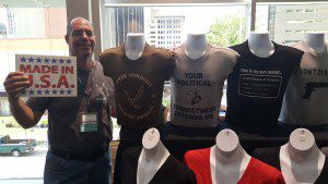 Scott Miller poses next to some of the T-shirts he's selling at the Southern Republican Leadership Conference in Oklahoma City.