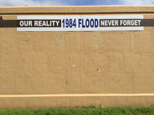A sign on the Tulsa levee along Charles Page Boulevard near 65th Street West commemorates the water level of the 1984 flood. KEVIN CANFIELD/The Frontier Cutline 2: Water from three tributaries rushes under Charles Page Boulevard and through a flood wall near 65th Street. KEVIN CANFIELD/The Frontier