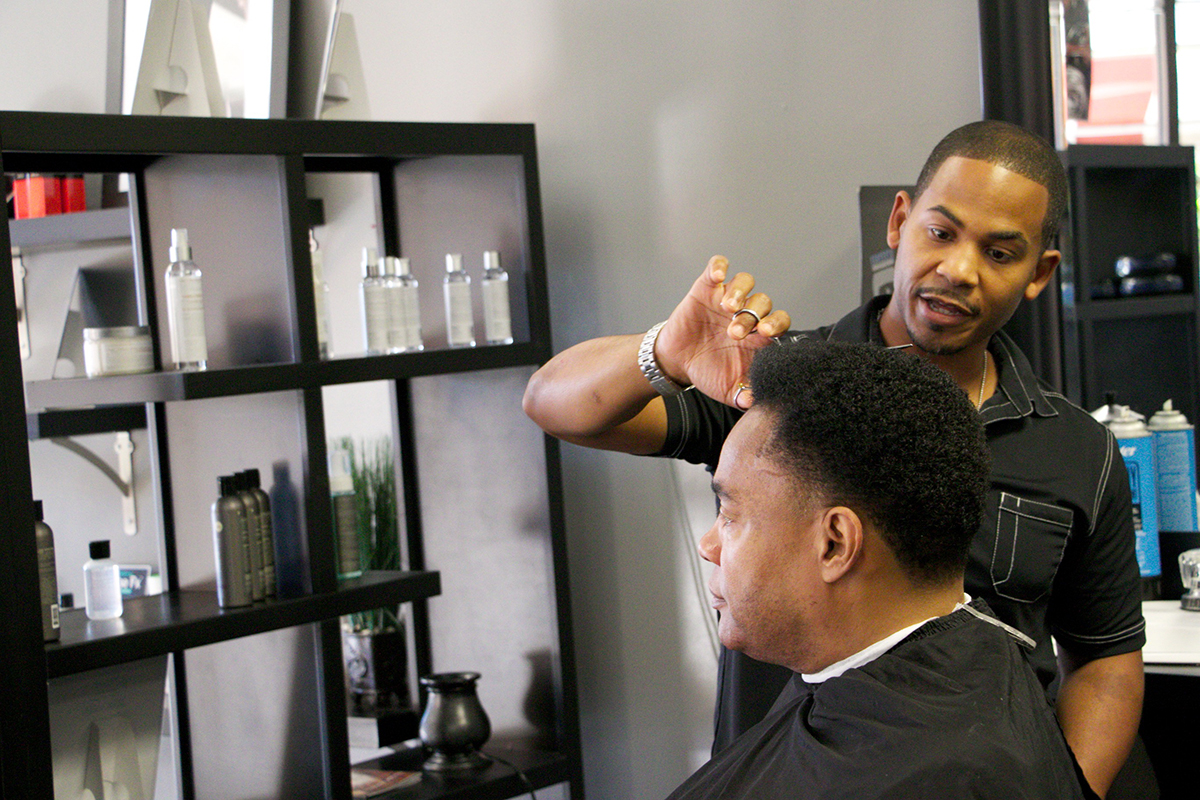 Tyson Thompson cuts a customer's hair Friday morning at Chris Tyson Grooming Co., 6939 S. Lewis Ave. Thompson has operated a barbershop on the corner of 71st and Lewis Avenue for nearly 20 years. DYLAN GOFORTH/The Frontier