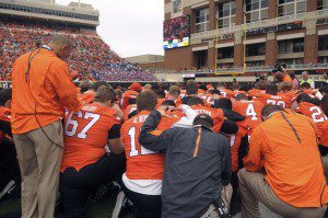 Coach Mike Gundy prays with OSU's football team before the game with Kansas Saturday. Photo courtesy of KOTV 